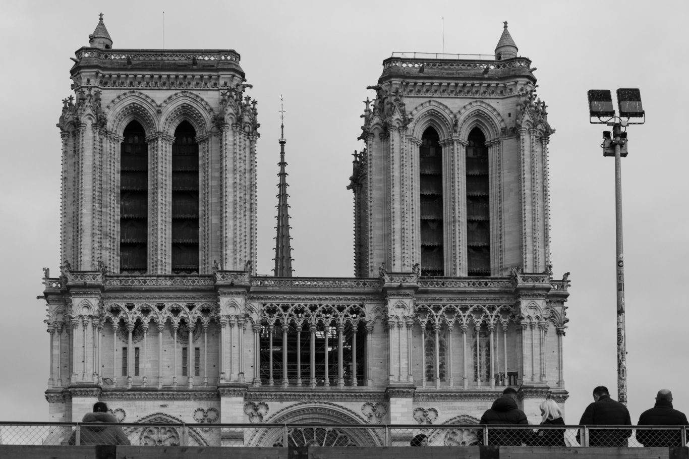 The towers of Notre-Dame Cathedral in black and white, clouds in the background.