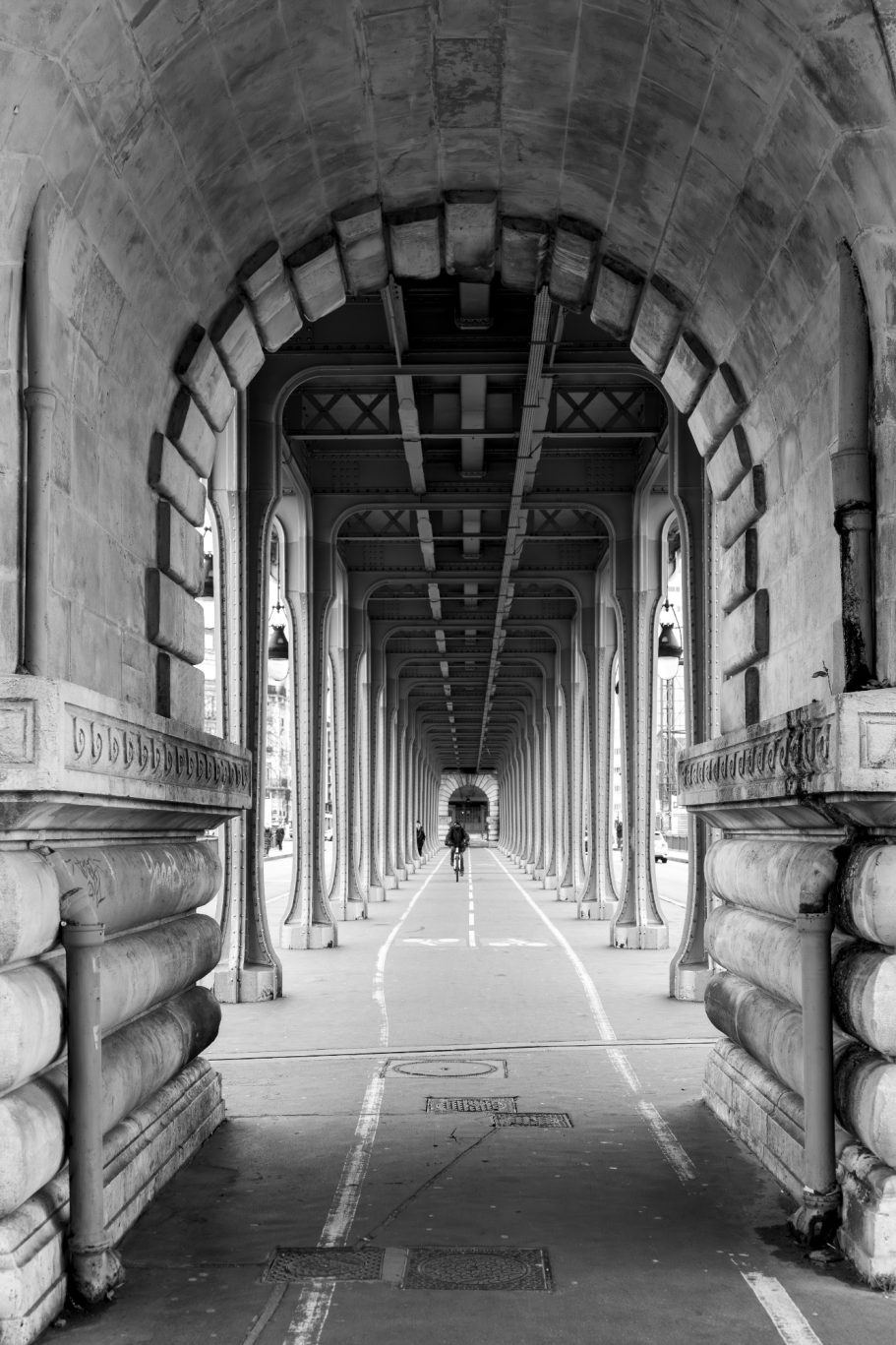 A long, symmetrical brick vault with a person in the distance.