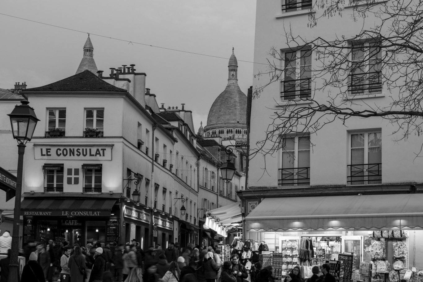 View of a busy street scene with the dome of a church in the background.
